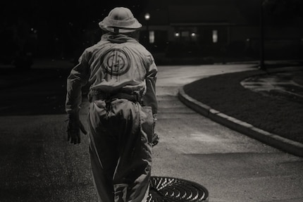 A beekeeper emerges from the sewer. Wrong street, buddy.