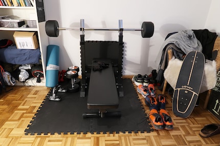 Un équipement minimaliste, mais efficace : un banc et quelques haltères pour de la musculation à domicile.
