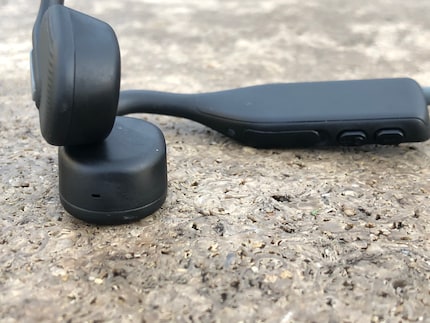 Here you can see the small microphone opening, the buttons for volume control and the charging port, which is protected by a plastic flap.