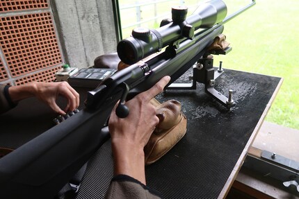 Claudio sitting, loading his weapon.