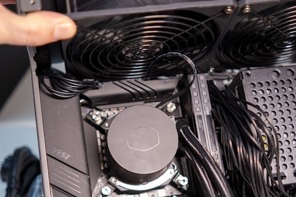 Le câble pour le CPU, déjà posé, est coincé entre la carte mère et les ventilateurs. Le raccordement de câble, plus ardu, demande de la patience.