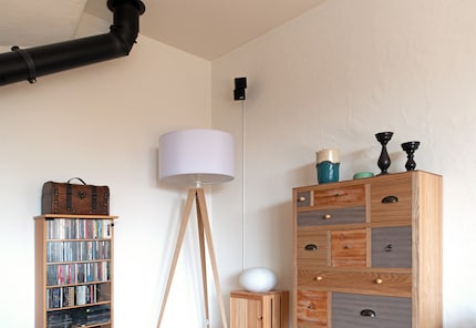 Discret, le petit haut-parleur double cube est fixé dans un coin.
