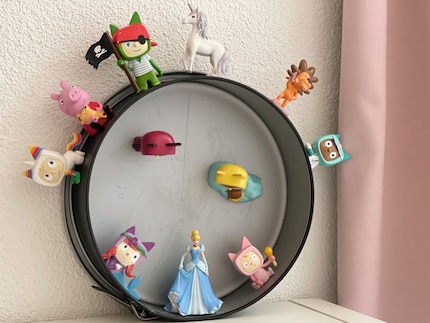 Old cake tin, new function: the magnetic figurines stick to the edge.