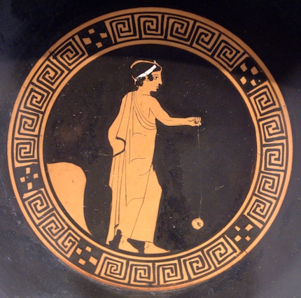 Une peinture grecque représentant un garçon jouant avec un yo-yo.