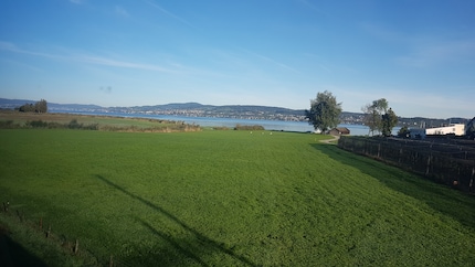 Vue sur le lac de Zurich à travers la fenêtre du train. L’anticipation de la randonnée augmente.
