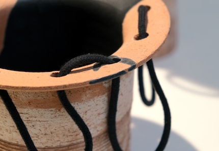 The cord is skilfully threaded through several holes.