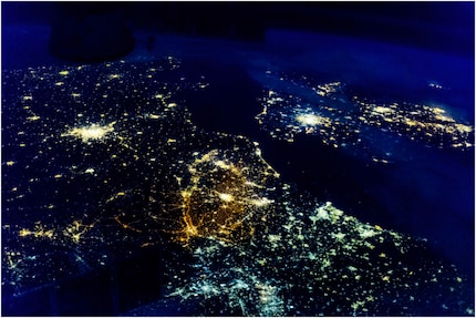 La Belgique et les pays voisins photographiés depuis l’ISS : notez les différentes couleurs de l’éclairage dans chaque pays. L’éclairage en Belgique paraît orange à cause des lampes à vapeur de sodium basse pression qu’on y utilise. Aux Pays-Bas (à droite), en France (à gauche) et au Royaume-Uni (en haut), la lumière est jaune, car ces pays utilisent des lampes à vapeur de sodium haute pression. La lumière bleutée en Allemagne (en bas de la carte) est due aux lampes à vapeur de mercure et aux tubes fluorescents qui y sont monnaie courante.