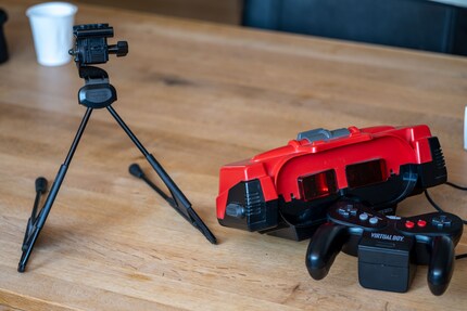 You control the Virtual Boy (right, centre) with a controller (right, bottom). Since it can’t be fixed to your head, you put it on a tripod (left).