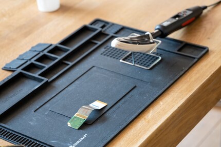 I place the lens with ribbon cable on a soldering pad.