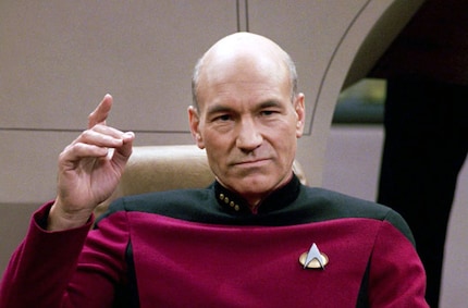 Patrick Stewart dans le rôle du capitaine Jean-Luc Piccard avec le pin Starfleet sur la poitrine.
