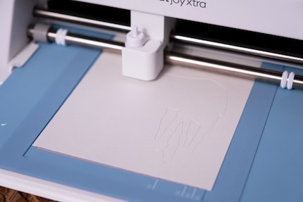 La carte de Noël TB-TT dans le Cricut avec le tapis de découpe pour cartes.