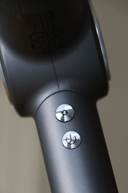 The auto-cycle/lock button at the top and the on/off/mode button at the bottom.