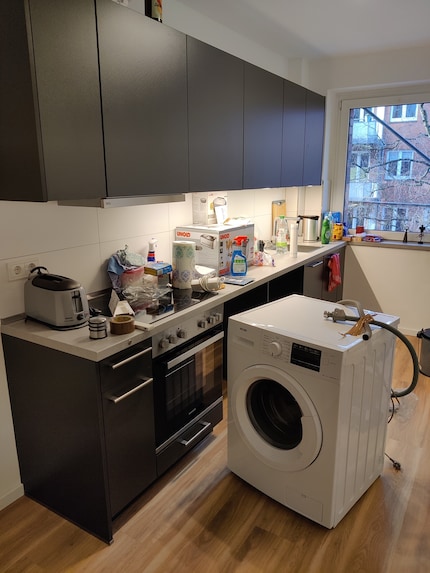 La vue de la cuisine : le lave-linge est au milieu de la pièce et doit encore être placé dans le coin cuisine.