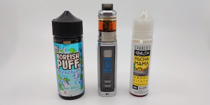 My e-cig lightsaber between refill liquids.