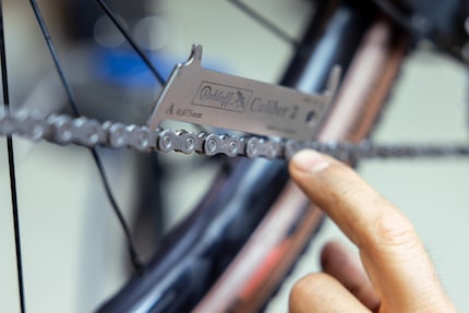 Elia Widmer using a chain wear gauge to measure the distance between the individual links.