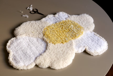 Une fois que le tapis est détaché du cadre, il peut être découpé.