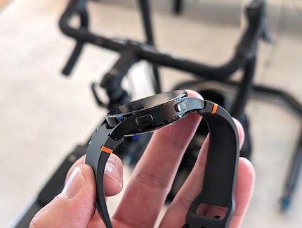La montre avec un boîtier noir et les petites touches de couleur sur le bracelet.