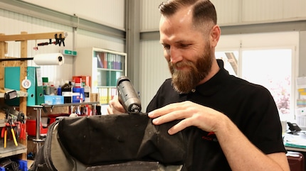 Concentré et habile de ses mains : le sac est remis en état.