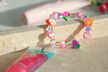 J'ai décoré le gloss d'Essence avec un élastique chargé de perles. Il peut ainsi être porté au poignet.