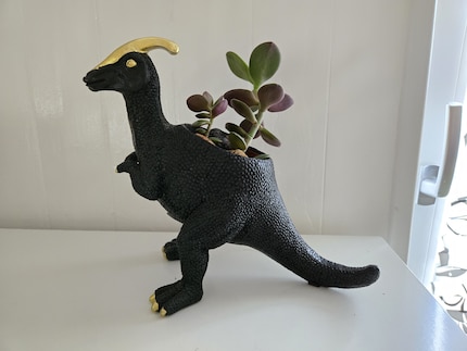 Toutes les écailles du dino noir sont bien visibles. Seules les pattes et la queue restent floues.