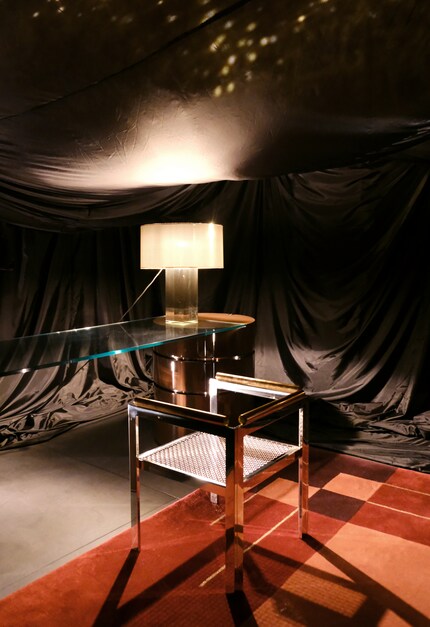 The surprisingly gloomy exhibition named Attracted to Light by Dimore showed a glass desk, a lamp with a Plexiglas base and a metal office chair with a perforated pattern.