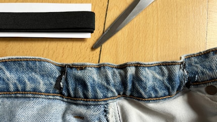 Faire passer l’élastique à l’intérieur de la ceinture et fixer chacune de ses extrémités aux fentes à l’aide d’épingles à nourrice. 