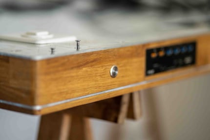 Voici à quoi ressemble la table lorsqu’elle est tournée à 180 degrés. On constate que les panneaux de bois et d’aluminium sont superposés à la manière d’un sandwich. 