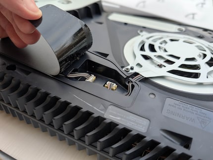Le couvercle, sous lequel se trouve la fiche du ventilateur, est collé.