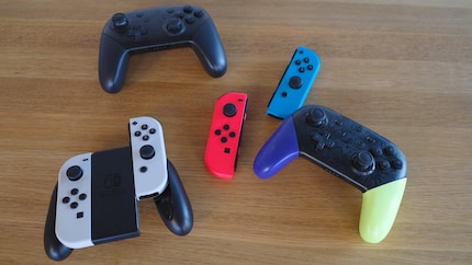 Joy-Cons dans le support (en bas à gauche), Joy-Cons détachés (au milieu) et deux manettes Pro (en haut à gauche et en bas à droite).