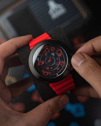 La montre est à gauche avec un bracelet orange (Plasma Pumpkin), à droite Supernova Red.