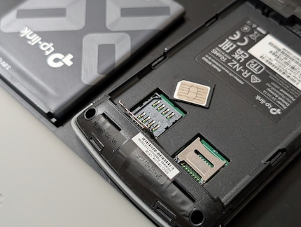The TP-Link is reminiscent of a cell phone from the 2000s with its cheap back cover and SIM card adapter.