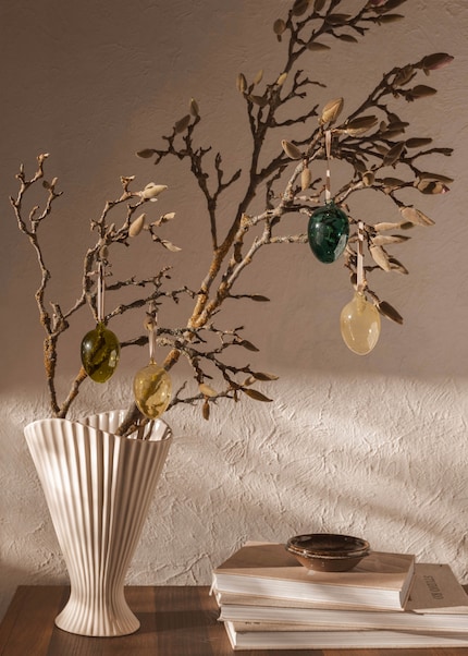 Un accroche-regard : l’arbuste de Pâques dans un vase plissé allie élégance et légèreté printanière.