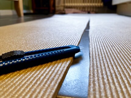 Le cutter glisse plus facilement à travers le tapis que je ne le pensais. Si facilement que les bords coupés sont un peu de travers. Oups !