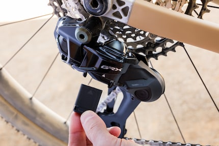 Comme sur le nouveau groupe XTR, la batterie pour la transmission électronique du nouveau groupe Gravel est élégamment intégrée dans le dérailleur.