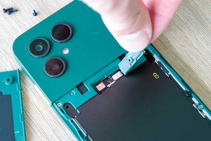 La batterie est fixée à l’aide de quatre vis et d’un connecteur.
