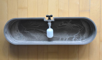 Le réservoir alimente en eau le T (noir) jusqu'à ce que la valve flottante (blanche) atteigne le niveau maximum.