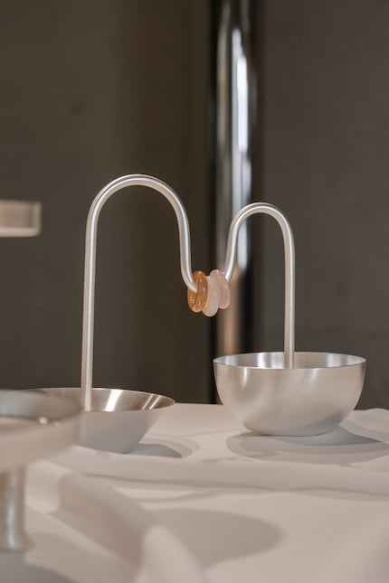 The two bowls of the aperitivo set are connected by a metal rod with three movable quartz stones.
