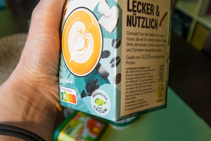 Alpro fait la promotion de son produit « Barista Kokos » sur le devant de l’emballage avec la mention « Végétal & avec du calcium ». Le V-label jaune est apposé sur le côté de l’emballage.