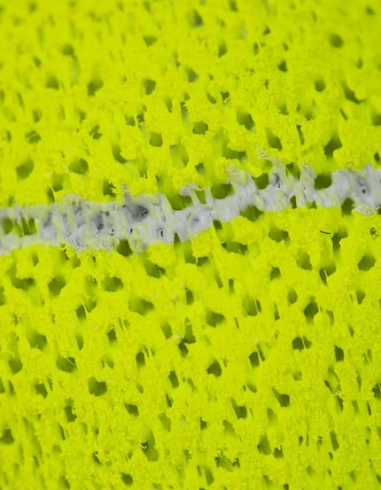 Prise de vue rapprochée de la surface alvéolée : la structure imprimée en 3D remplace le caoutchouc et le feutre des balles de tennis classiques.